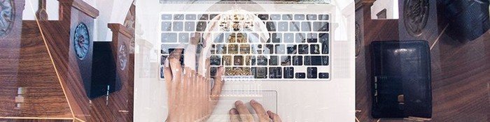 Bærbar computer foran billede af Nørre Tranders Kirke indendørs